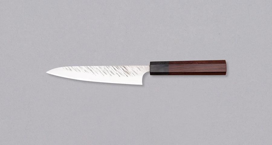 Kurosaki Petty linije Fujin je še eno unikatno rezilo iz rok nadarjenega kovaškega mojstra Yu Kurosakija. Nož odlikuje izjemna ostrina in unikaten dizajn. Sredica noža je iz prašnega jekla SG2 (63 HRC!). Rezilo ima unikaten črtast tsuchime vzorec in tradicionalni japonski ročaj iz palisandra z obročkom iz pakka lesa.
