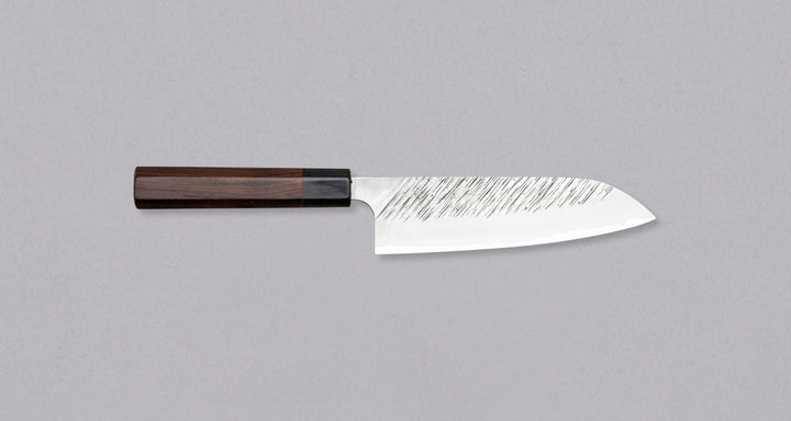 Kurosaki santoku iz linije Fujin je še eno unikatno rezilo iz rok nadarjenega mladega kovaškega mojstra Yu Kurosakija. Unikatne črte na rezilu spominjajo na veter, zato je tudi ta linija poimenovana po Fujinu, japonskemu bogu vetra. Nož ima tradicionalen japonski ročaj iz palisandra. Optimalen za vsakdanjo uporabo.