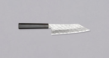 Nigara Bunka VG-10 Damascus Tsuchime 180 mm je večnamenski japonski kuhinjski nož, primeren za pripravo mesa, rib in zelenjave. Jedro iz nerjavečega VG-10 jekla zagotavlja dolgotrajno ostrino ter minimalno vzdrževanje. Izjemne lastnosti in videz rezila dopolnjuje ročaj japonskega tipa (Wa) iz luksuzne ebenovine.