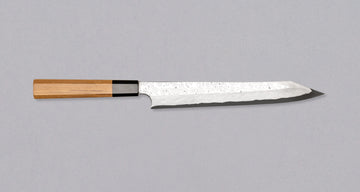 Nigara Kurozome Kiritsuke Yanagiba Aogami #2 Damascus 240 mm je tradicionalni japonski nož, ki se uporablja za pripravo rib (zlasti za sashimi in nigiri sushi). Dolgo rezilo omogoča lepe in dolge gibe, prirezana konica pa natančen zaključek reza.