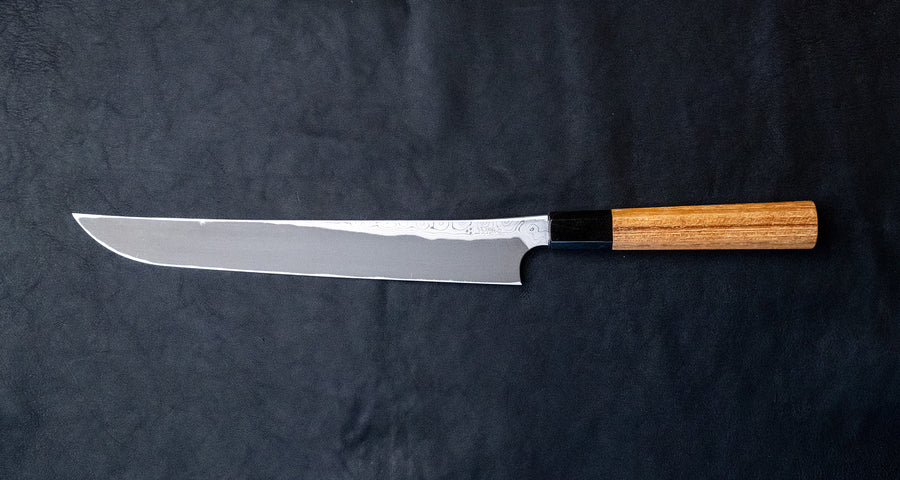 Nigara Kurozome Sakimaru Yanagiba Aogami #2 Damascus 270 mm je tradicionalni japonski nož, ki se uporablja za pripravo rib. Ime sakimaru se nanaša na tanto konico, ki je poklon katani. Dolgo rezilo omogoča lepe in dolge gibe, prirezana konica pa natančen zaključek reza. 