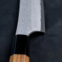 Nigara Kurozome Yanagiba Aogami #2 Damascus 270 mm je tradicionalni japonski nož za pripravo rib. Kakovost in izdelava tega noža sta vrhunska – od choila do edinstvenega damask vzorca. Zunanji sloji rezila imajo bisernemu mozaiku podoben videz, česar niti pri najbolj vrhunskih rezilih ne boste pogosto zasledili. 