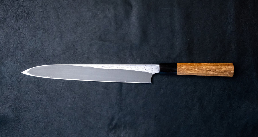 Nigara Kurozome Yanagiba Aogami #2 Damascus 270 mm je tradicionalni japonski nož za pripravo rib. Kakovost in izdelava tega noža sta vrhunska – od choila do edinstvenega damask vzorca. Zunanji sloji rezila imajo bisernemu mozaiku podoben videz, česar niti pri najbolj vrhunskih rezilih ne boste pogosto zasledili. 