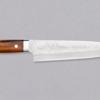 Saji Gyuto SRS13 Tsuchime 240 mm je vsestranski japonski kuhinjski nož, primeren za pripravo mesa, rib in zelenjave in je resnično izjemen primerek japonske kovaške spretnosti. Srce tega noža je skovano iz SRS13, hitroreznega prašnega jekla, ki ga odlikujeta visoka trdota in odlična odpornost proti koroziji.