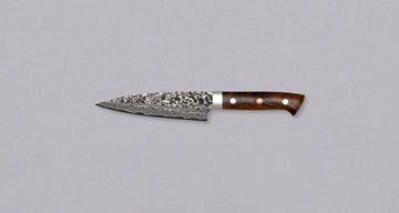 Saji Petty R2 Ironwood 130 mm je nož kovača Takeshi Sajija. Saji je kovač tretje generacije iz slavnega kovaškega središča Takefu Knife Village. S svojo novo omejeno serijo Rainbow Damascus je ustvaril mojstrske nože iz prašnega jekla R2 s temnim damask vzorcem.