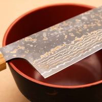 Saji Santoku VG-10 Gold RWO 165 mm je vsestranski japonski kuhinjski nož, primeren za pripravo mesa, rib in zelenjave. Vendar bi mu delali krivico, če bi ga imenovali samo kuhinjski nož, saj je resnično izjemen primerek japonske kovaške spretnosti, od njegovega videza in vse do specifičnih detajlov.