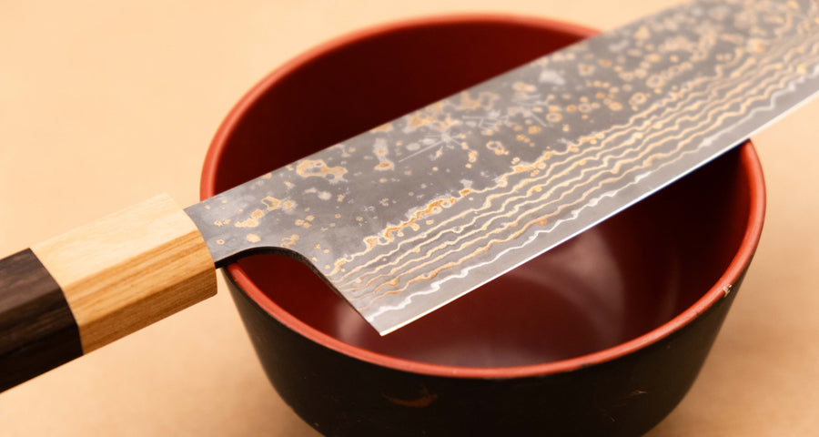 Saji Santoku VG-10 Gold RWO 165 mm je vsestranski japonski kuhinjski nož, primeren za pripravo mesa, rib in zelenjave. Vendar bi mu delali krivico, če bi ga imenovali samo kuhinjski nož, saj je resnično izjemen primerek japonske kovaške spretnosti, od njegovega videza in vse do specifičnih detajlov.