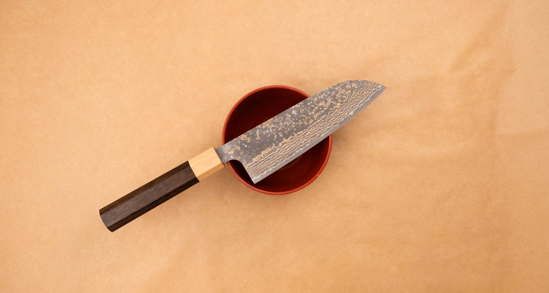 Saji Santoku VG-10 Gold RWO 165 mm je vsestranski japonski kuhinjski nož, primeren za pripravo mesa, rib in zelenjave. Vendar bi mu delali krivico, če bi ga imenovali samo kuhinjski nož, saj je resnično izjemen primerek japonske kovaške spretnosti, od njegovega videza in vse do specifičnih detajlov.