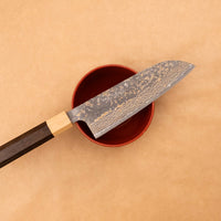 Saji Santoku VG-10 Gold RWO 165 mm je vsestranski japonski kuhinjski nož, primeren za pripravo mesa, rib in zelenjave. Vendar bi mu delali krivico, če bi ga imenovali samo kuhinjski nož, saj je resnično izjemen primerek japonske kovaške spretnosti, od njegovega videza in vse do specifičnih detajlov.