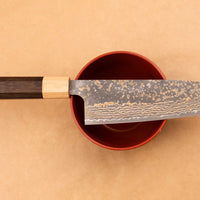 Saji Santoku VG-10 Gold RWO 165 mm je vsestranski japonski kuhinjski nož, primeren za pripravo mesa, rib in zelenjave. Vendar bi mu delali krivico, če bi ga imenovali samo kuhinjski nož, saj je resnično izjemen primerek japonske kovaške spretnosti, od njegovega videza in vse do specifičnih detajlov.