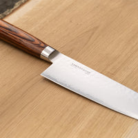 Tamahagane "TSUBAME" Santoku 175 mm je izdelan iz VG-5 nerjavečega jekla in ima ročaj iz pakka lesa v zahodnem stilu. Zanesljiv in nezahteven nož, odličen za profesionalne kuhinje.