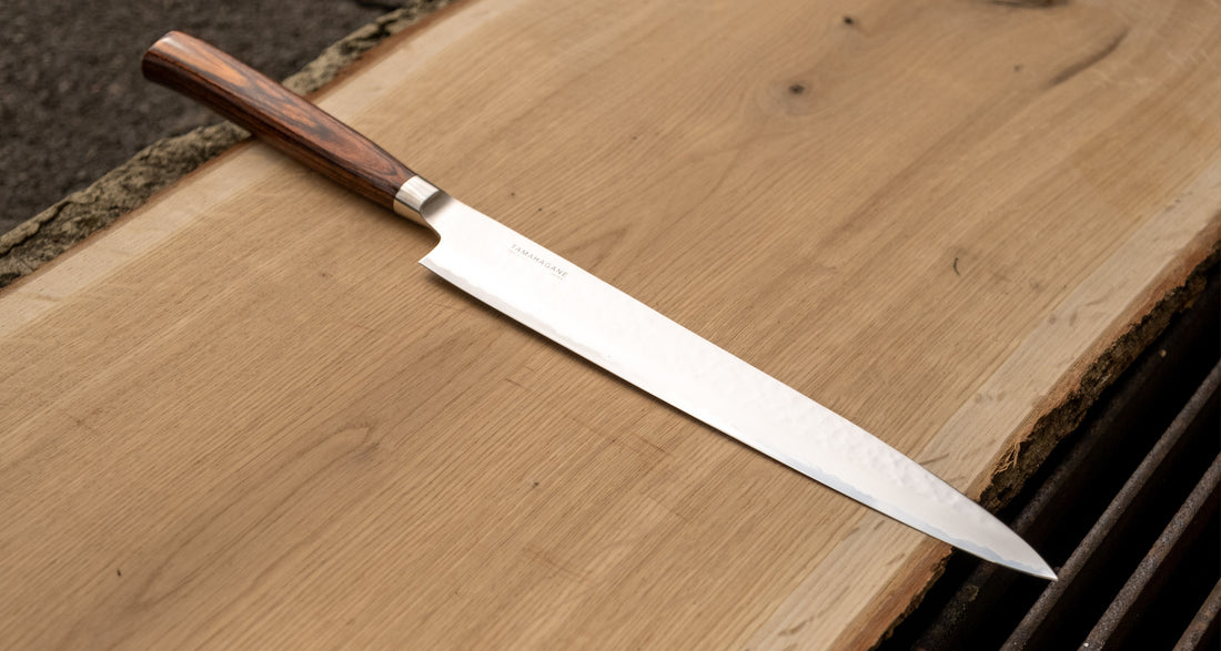 Tamahagane "TSUBAME" Sashimi-Slicer 240mm je izdelan iz VG-5 nerjavečega jekla in ima zelo vzdržljiv in vodoodporen ročaj iz pakka lesa. Izjemno nezahteven in zanesljiv nož, primeren za profesionalne kuharje.