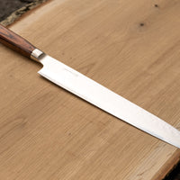 Tamahagane "TSUBAME" Sashimi-Slicer 240mm je izdelan iz VG-5 nerjavečega jekla in ima zelo vzdržljiv in vodoodporen ročaj iz pakka lesa. Izjemno nezahteven in zanesljiv nož, primeren za profesionalne kuharje.