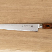 Tamahagane "TSUBAME" Sujihiki 240 mm je nezahtevebn in zanesljiv nož iz VG-5 nerjavečega jekla, ki je perfekten za profesionalno uporabo. Opremljen je z ročajem zahodnega tipa iz trpežnega, vodoodpornega pakka lesa.