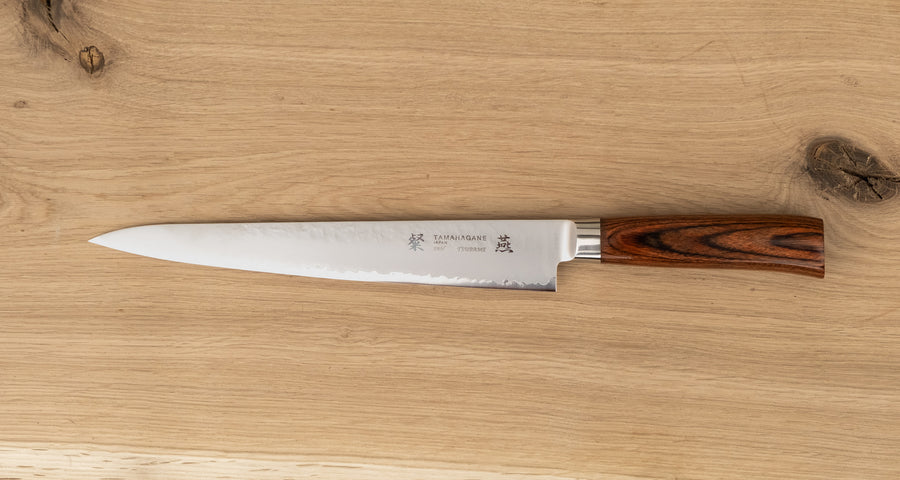 Tamahagane "TSUBAME" Sujihiki 240 mm je nezahtevebn in zanesljiv nož iz VG-5 nerjavečega jekla, ki je perfekten za profesionalno uporabo. Opremljen je z ročajem zahodnega tipa iz trpežnega, vodoodpornega pakka lesa.