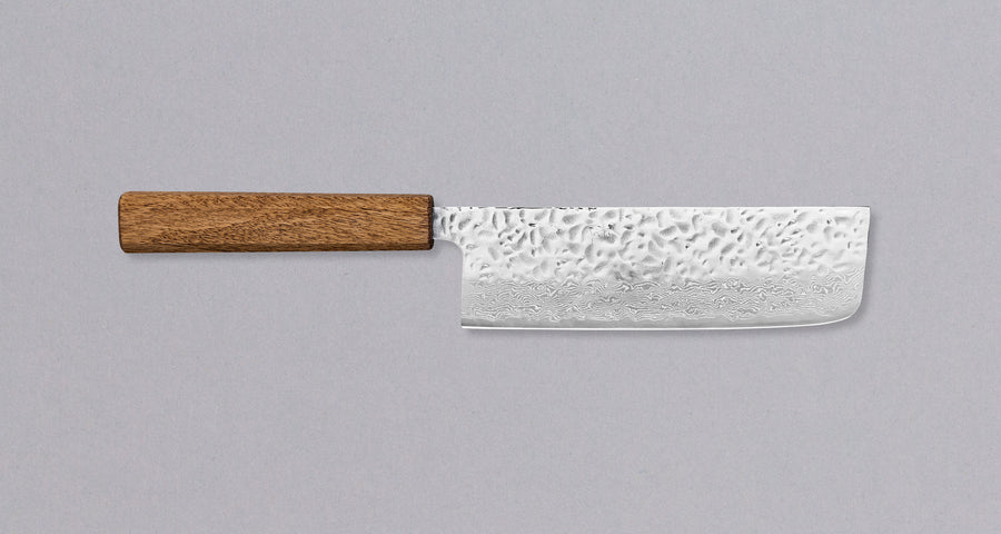 Tsunehisa Nakiri Damascus Tsuchime Oak 165 mm. Ima rezilo z damask vzorcem in odtisi kladiv ter preprost, a obstojen tradicionalni Wa ročaj iz lesa hrasta. Zaradi zelo tankega rezila, ki mu sledi še tanjše konkavno brušenje, ta nož uvrščamo v kategorijo lahkih, srednje velikih japonskih nožev. Visoko zmogljivo jeklo, čist japonski dizajn, enostavno vzdrževanje in cena, prijazna denarnici.