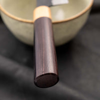 Tsunehisa Kiritsuke AS Kuro-uchi 240 mm je japonski nož, ki ga poleg enega najboljših jekel za kuhinjske nože in popolnega profila rezila (zelo tanko rezilo!), zaznamuje tudi unikatna kombinacija temne patine in odtisov kladiva, ki ju vizualno lepo dopolnjuje klasičen japonski ročaj iz palisandra in javorjevega lesa.