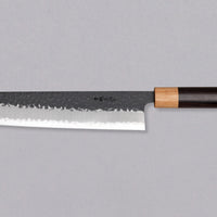 Tsunehisa Kiritsuke AS Kuro-uchi 240 mm je japonski nož, ki ga poleg enega najboljših jekel za kuhinjske nože in popolnega profila rezila (zelo tanko rezilo!), zaznamuje tudi unikatna kombinacija temne patine in odtisov kladiva, ki ju vizualno lepo dopolnjuje klasičen japonski ročaj iz palisandra in javorjevega lesa.