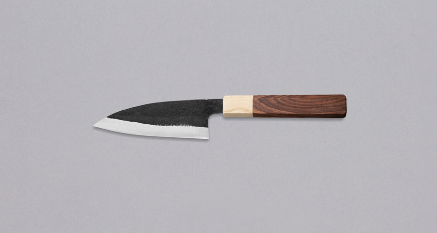Yoshida Ajikiri SUJ-2 Kuro-uchi 100 mm [Rosewood-Cedar] je tradicionalen japonski nož za filiranje manjših rib. Sredica noža je izdelana iz SUJ-2 jekla, rezilo pa je opremljeno s tradicionalnim japonskim ročajem iz palisandra, ki na vrhu prehaja v zaključni obroček iz lesa cedre. 