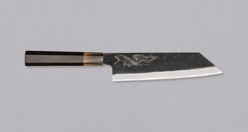 Yoshida Bunka SUJ-2 Kuro-uchi 190 mm ročno izdelan kuhinjski nož iz serije Yoshida Hamono, s trpežnim SUJ-2 jeklom, rustikalnim kuro-uchi zaključkom, ročajem iz ebenovine ter unikatno gravuro koi krapa, idealen za raznolika kuhinjska opravila in kot darilo.