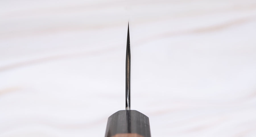 ZDP-189 Kiritsuke 240 mm - Choil noža. Kiritsuke je večnamenski japonski kuhinjski nož za različna opravila, predvsem pa se bo odlično izkazal za pripravo mesa in sekljanje večjih količin zelenjave. Kiritsuke je po funkcionalnosti precej podoben gyuto rezilom, razlikuje se po izraziti sprednji konici, ki je ravno prirezana, čemur pravimo tudi "k-tip". 