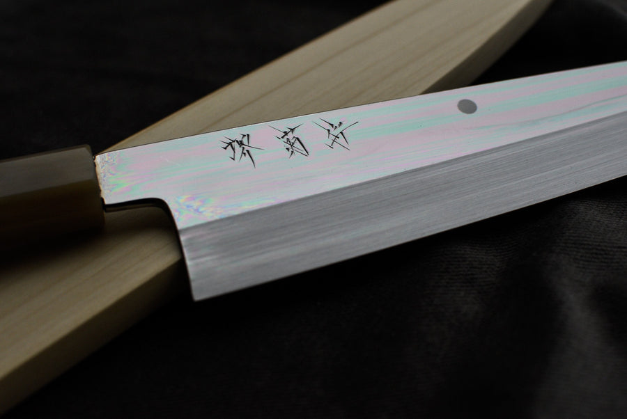 Kawamura Mizu-Honyaki Gyuto je ročno kovan nož, izdelan z neverjetno natančnostjo, ki je plod stoletja izkušenj in učenja. Gre za preplet odličnega delovnega orodja in umetniškega dela. Honyaki se lahko prevede kot “resnično kovan” in ta način kovanja je najčistejši odraz tradicionalne japonske umetnosti izdelave mečev. 