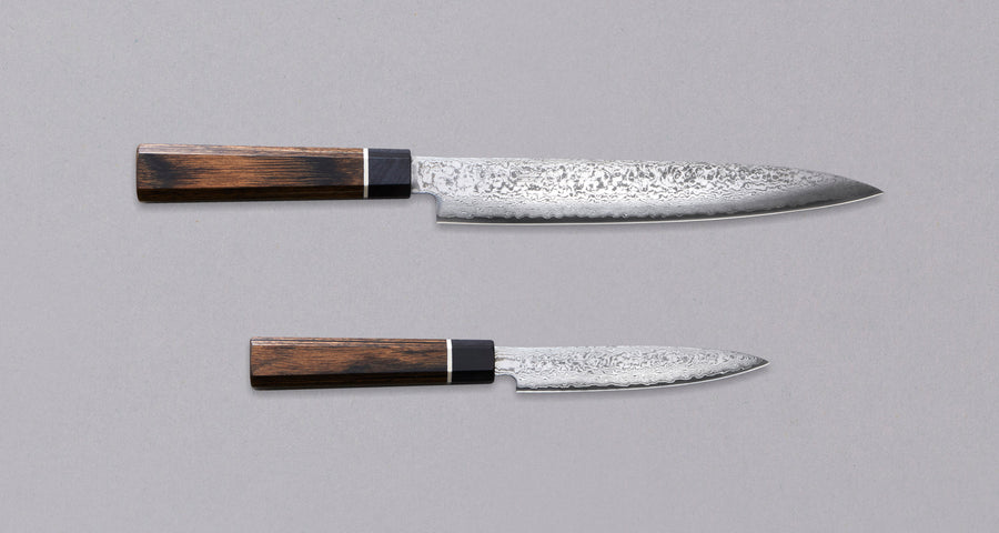 Black Damascus linija je naša linija nožev s 33-slojnim damask vzorcem, zaradi katerega je vsak kos povsem unikaten. Senzo Black Damascus se kuje v kovačiji Suncraft. Ta set je sestavljen iz japonskega kuhinjskega noža Black Damascus Slicer 210 mm in Black Damascus Utility 120 mm, izdelana sta iz odličnega VG-10 jekla.