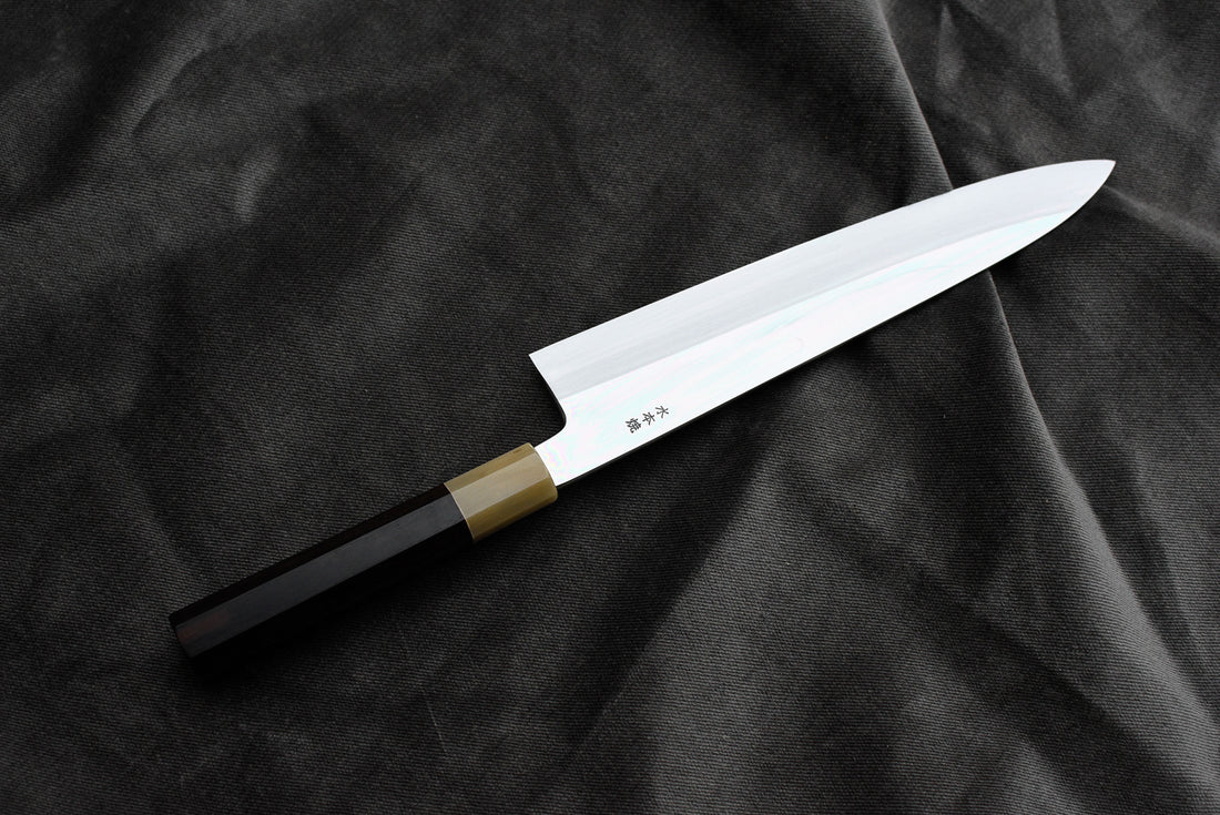 Kawamura Mizu-Honyaki Gyuto je ročno kovan nož, izdelan z neverjetno natančnostjo, ki je plod stoletja izkušenj in učenja. Gre za preplet odličnega delovnega orodja in umetniškega dela. Honyaki se lahko prevede kot “resnično kovan” in ta način kovanja je najčistejši odraz tradicionalne japonske umetnosti izdelave mečev. 